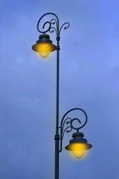 Image of Beautiful old fashioned street lamps lighting outdoors