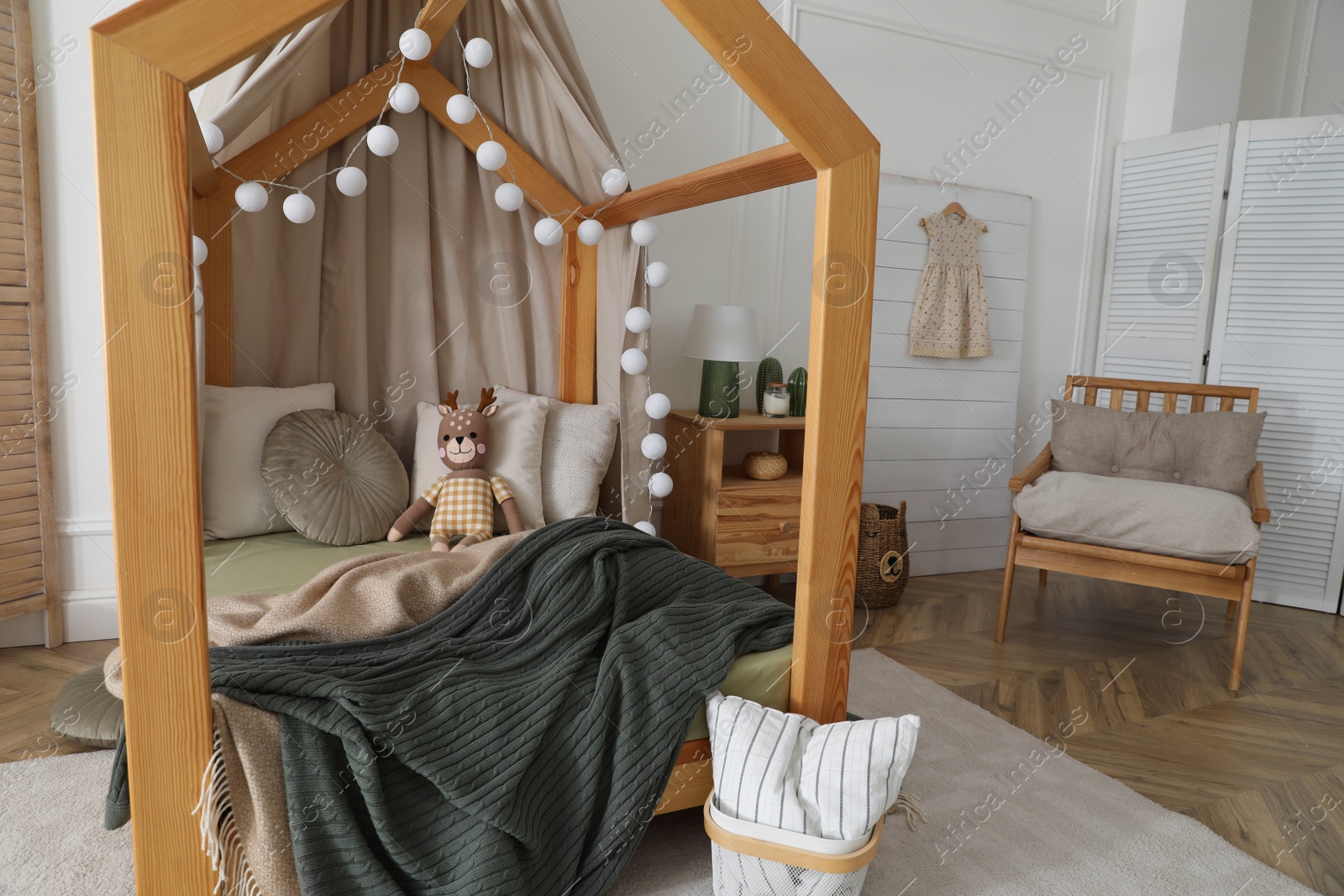 Photo of Stylish child room interior with wooden house bed