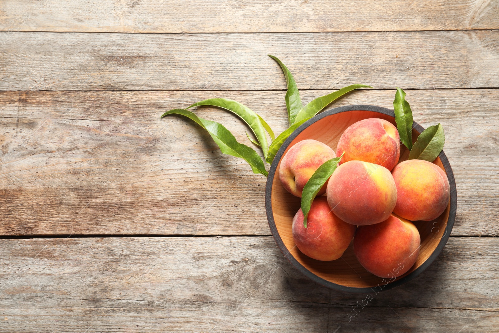 Photo of Plate with fresh sweet peaches on wooden table, top view