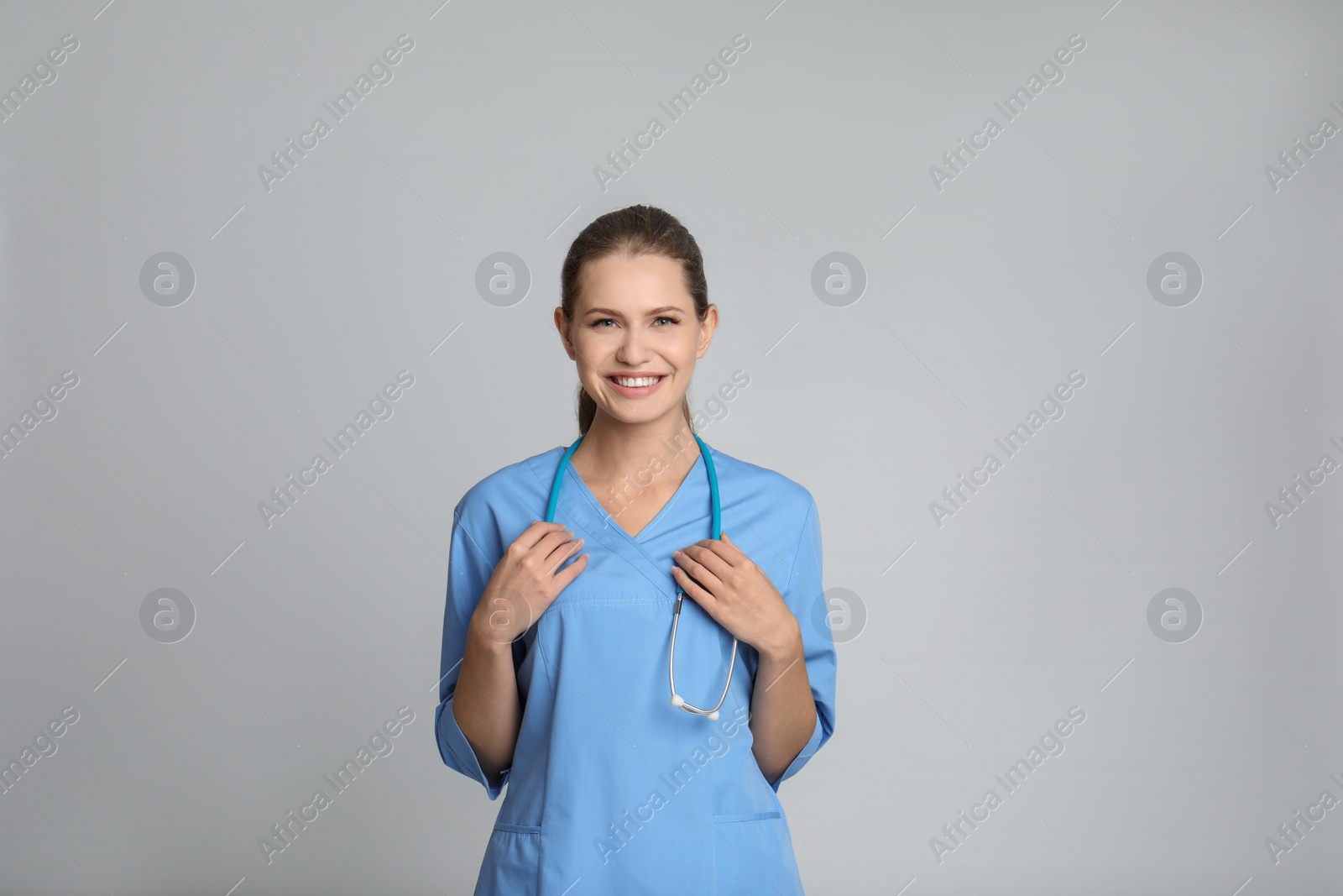 Photo of Portrait of young medical assistant with stethoscope on color background