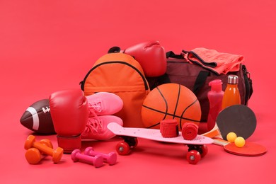 Many different sports equipment on red background