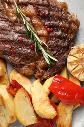 Photo of Delicious grilled beef steak and vegetables on plate, top view