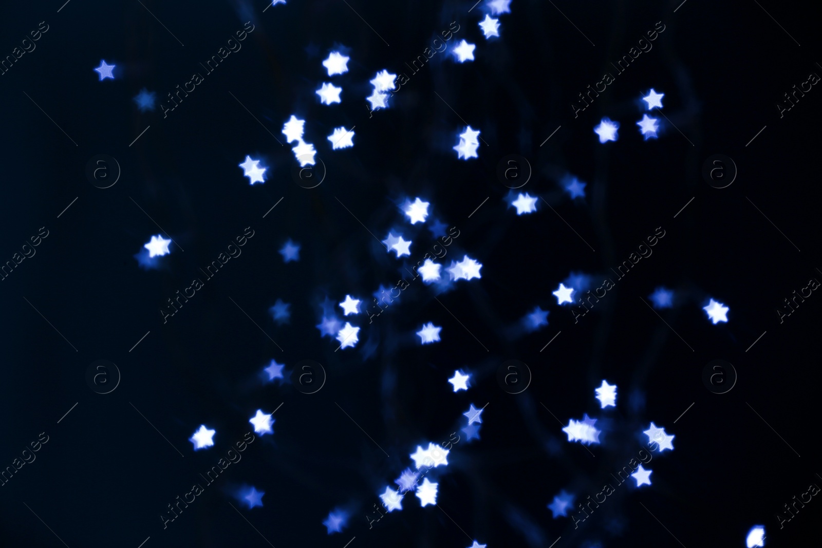 Photo of Blurred view of star shaped lights on black background. Bokeh effect