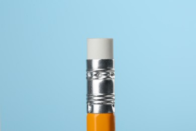 Photo of Graphite pencil with eraser on turquoise background, macro view