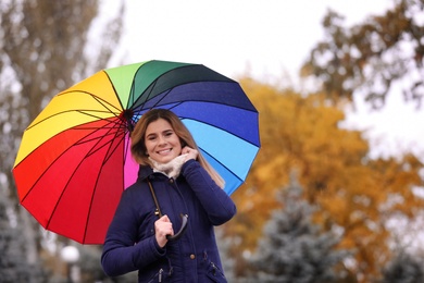 Woman with umbrella in autumn park on rainy day