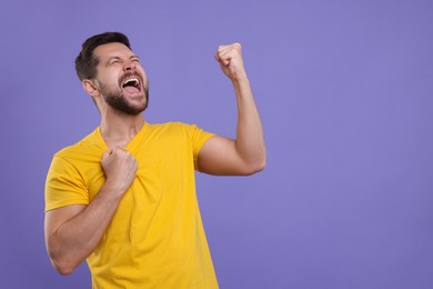 Emotional sports fan celebrating on purple background. Space for text