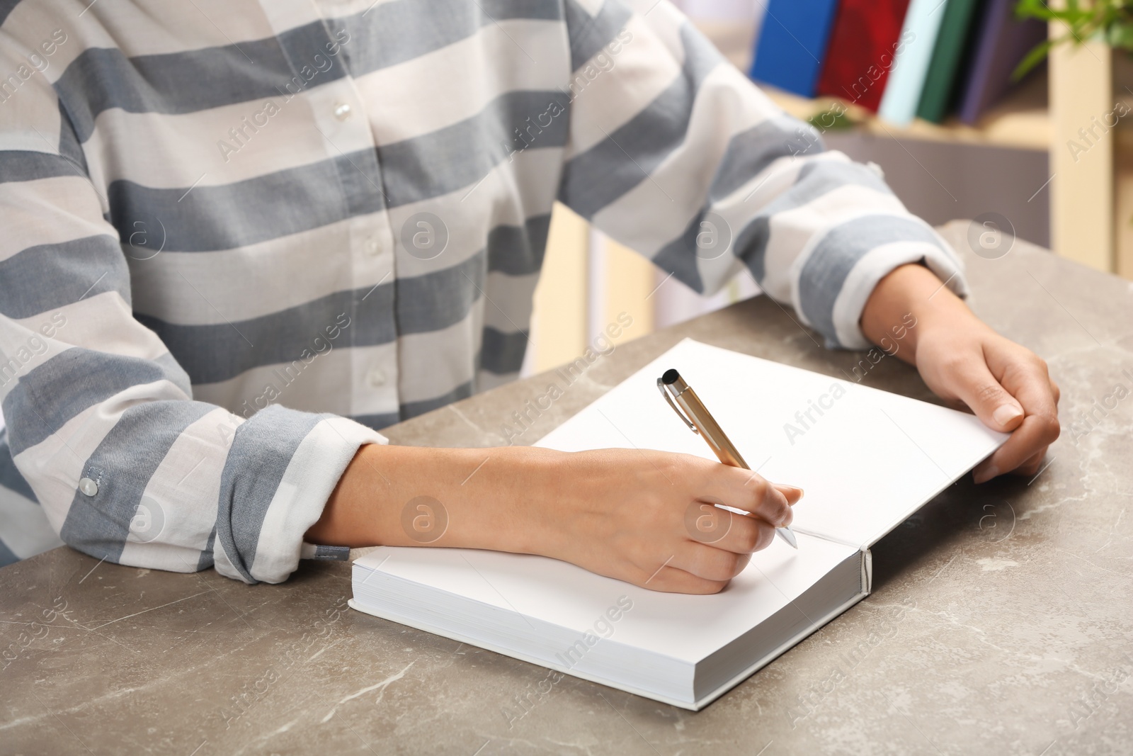 Photo of Writer signing autograph in book at table, closeup