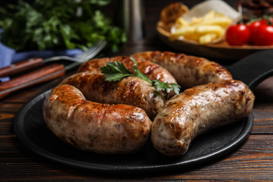 Photo of Delicious fresh grilled sausages on wooden table