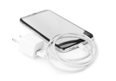 Photo of Smartphone and USB charger on white background. Modern technology