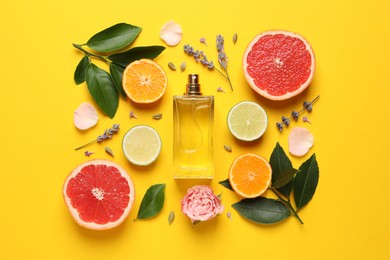 Flat lay composition with bottle of perfume and fresh citrus fruits on yellow background