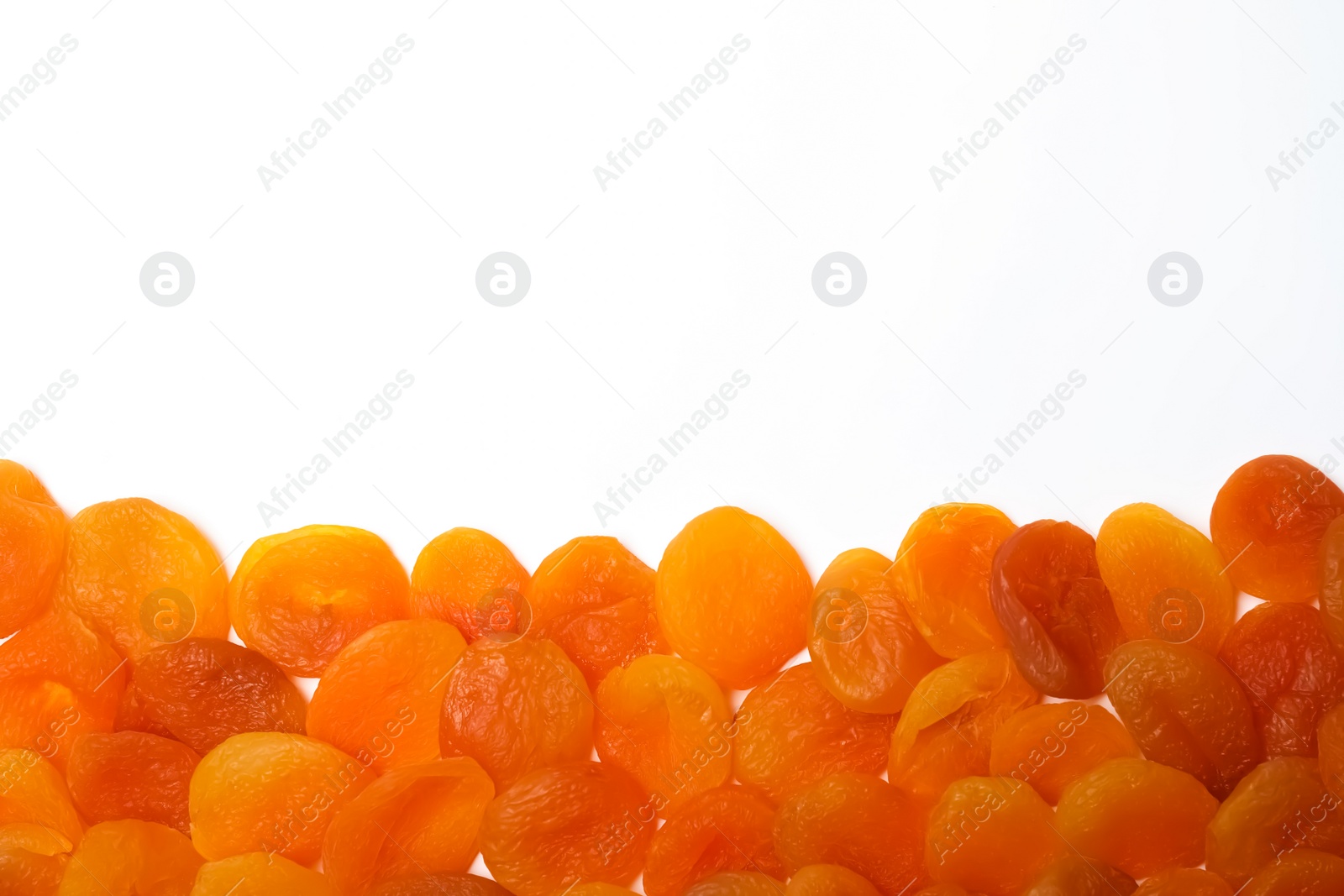 Photo of Dried apricots on white background, top view with space for text. Healthy fruit