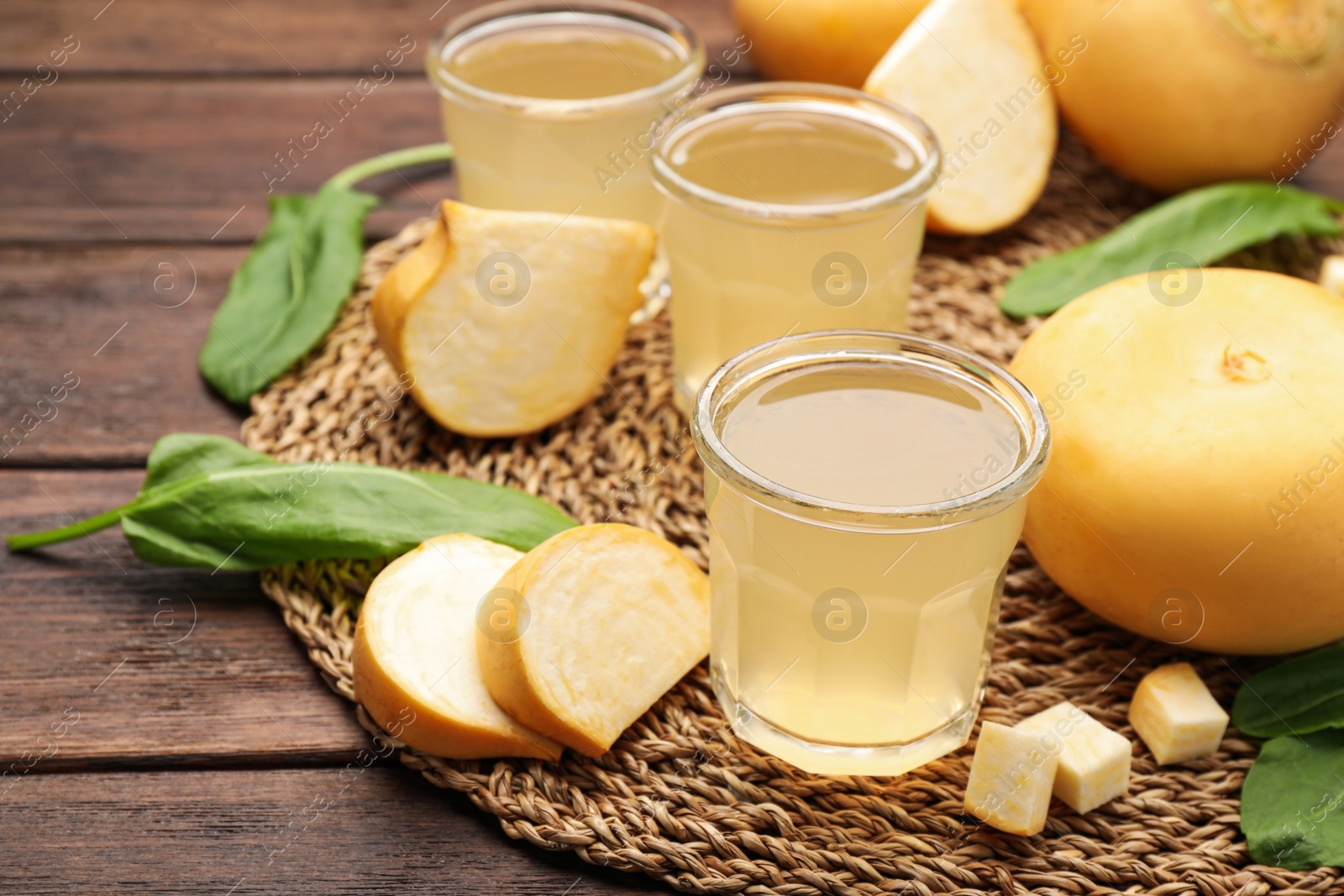 Photo of Glasses of freshly made turnip juice on wooden table