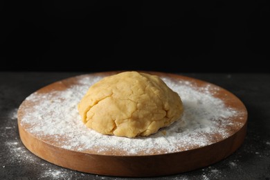 Photo of Making shortcrust pastry. Raw dough and flour on grey table