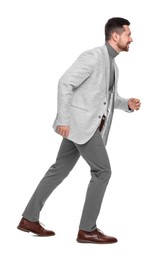 Photo of Handsome bearded businessman walking on white background