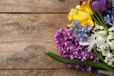 Beautiful spring flowers on wooden table, top view. Space for text