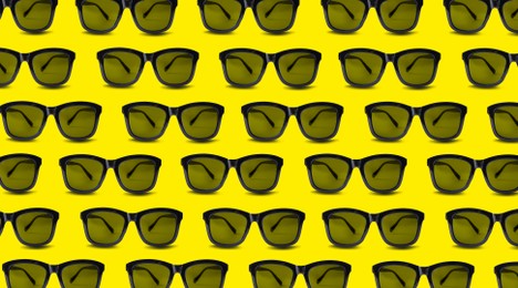 Image of Many stylish sunglasses on yellow background. Seamless pattern design