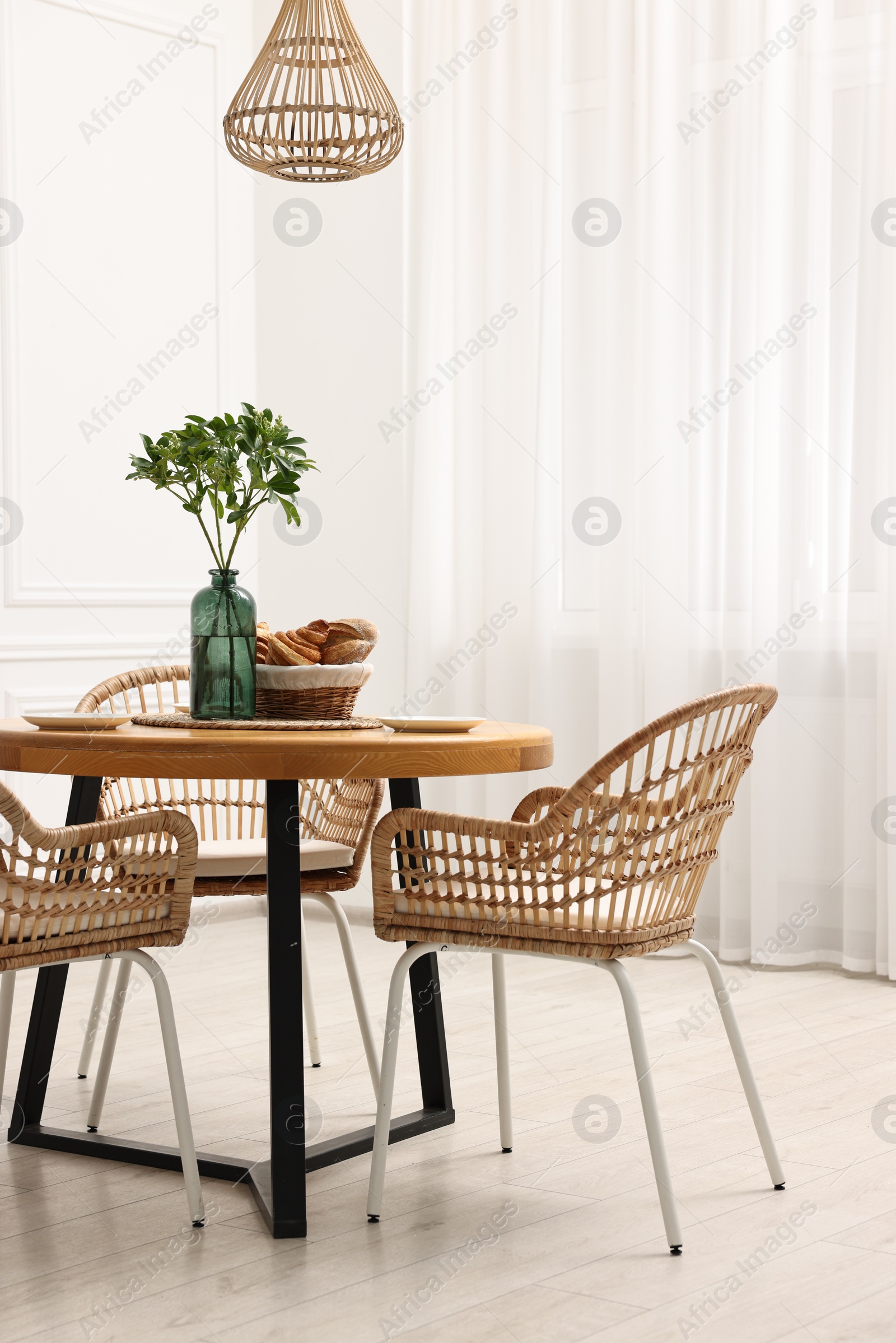 Photo of Dining room interior with comfortable furniture and green branches