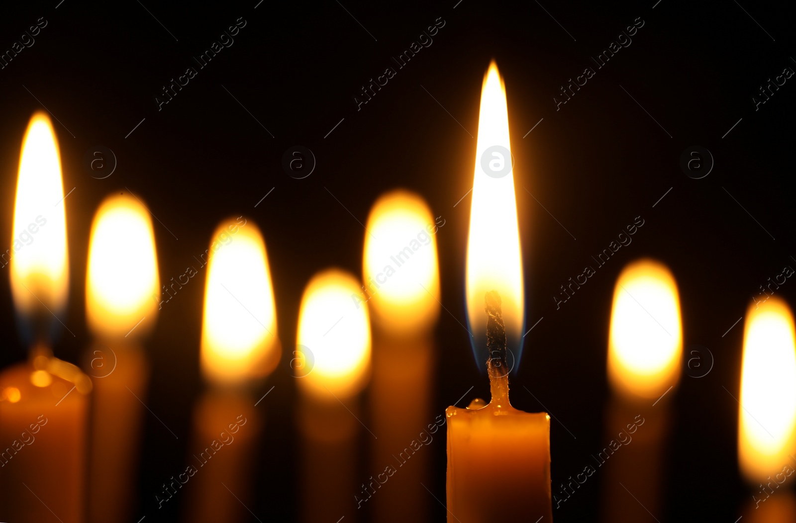 Photo of Burning candles on dark background, space for text. Symbol of sorrow