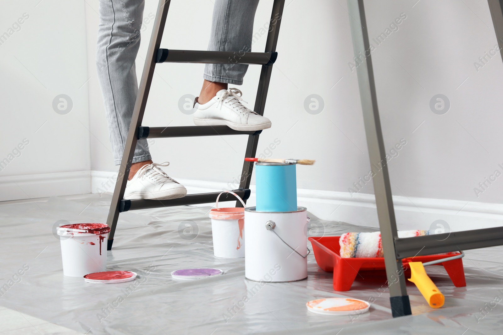 Photo of Young man climbing up ladder indoors, closeup