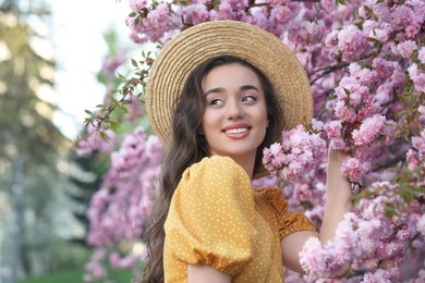 Beautiful woman near blossoming sakura tree on spring day