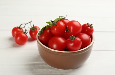 Photo of Fresh ripe cherry tomatoes on white wooden table