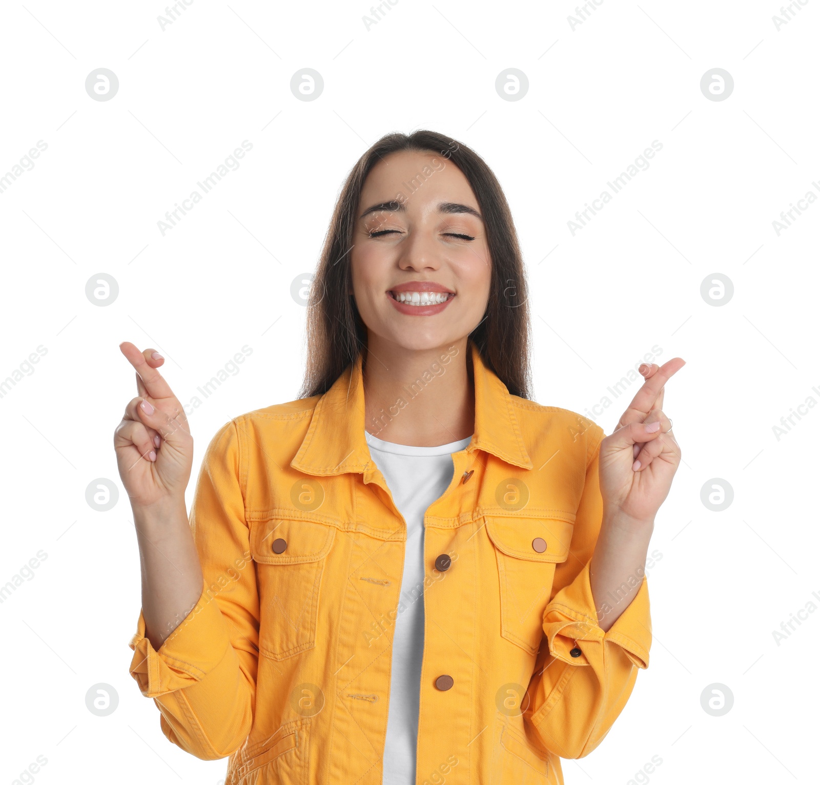 Photo of Excited young woman holding fingers crossed on white background. Superstition for good luck 