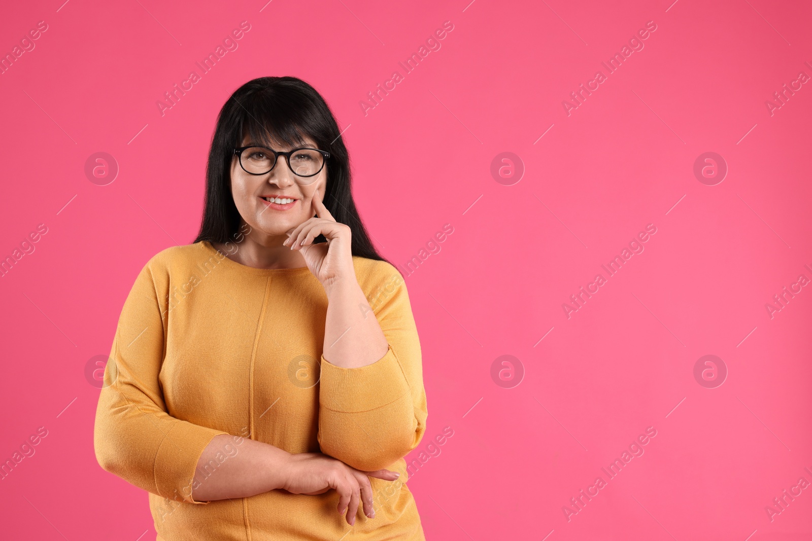 Photo of Beautiful overweight mature woman with charming smile on pink background. Space for text