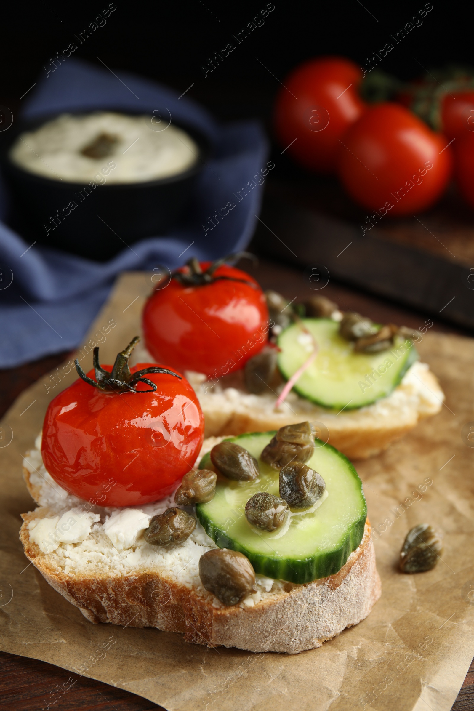 Photo of Tasty bruschettas with vegetables and capers on table, closeup