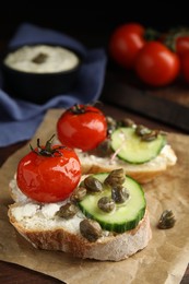 Photo of Tasty bruschettas with vegetables and capers on table, closeup