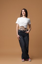 Photo of Full length portrait of smiling tattooed woman on beige background