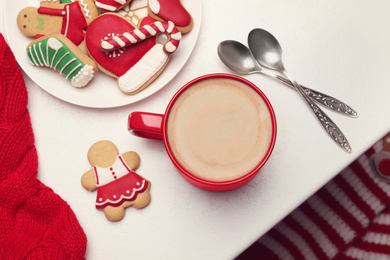 Cup of hot coffee and cookies on white table, top view. Winter drink