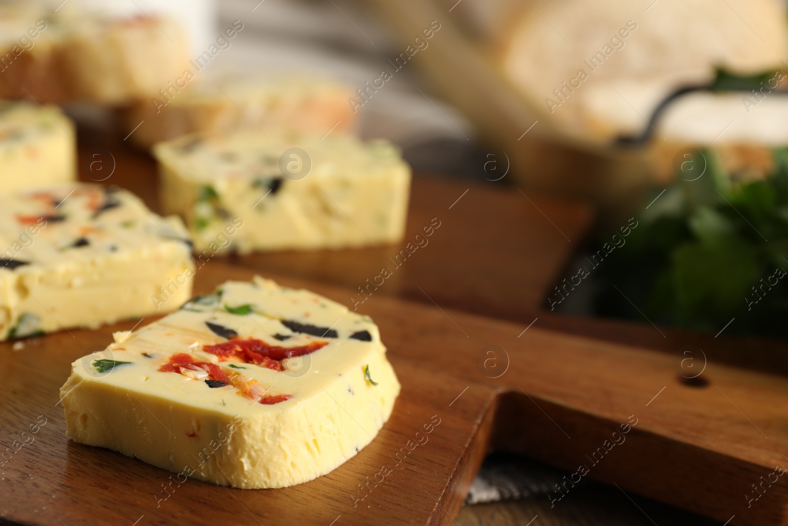 Photo of Tasty butter with olives, chili pepper and parsley on table, closeup. Space for text