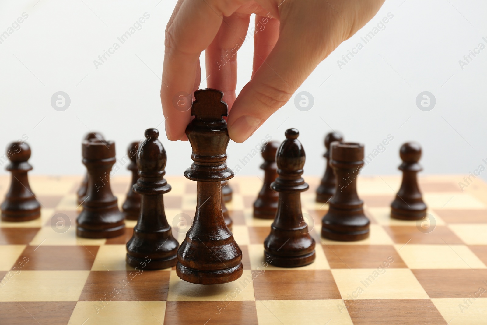 Photo of Woman putting chess piece on board, closeup. Career promotion concept