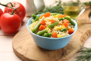 Photo of Delicious bulgur with vegetables in bowl on table, closeup