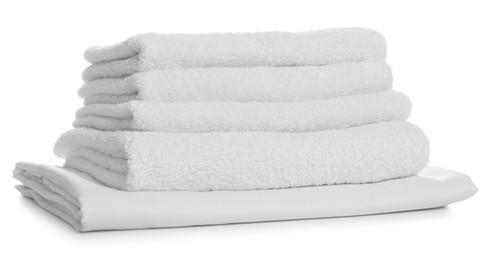 Photo of Stack of towels and bed sheet on white background