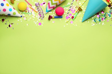Photo of Beautiful flat lay composition with festive items on light green background, space for text. Surprise party concept
