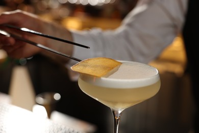 Photo of Bartender making fresh alcoholic cocktail in bar, closeup
