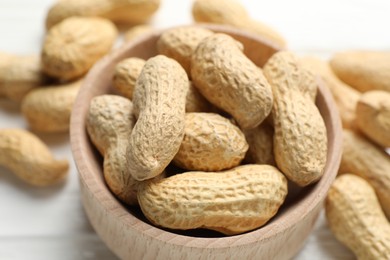 Photo of Fresh peanuts in bowl on table, closeup