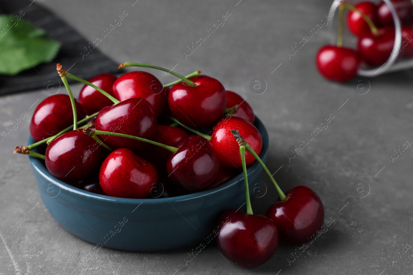 Photo of Fresh ripe cherries on grey table, closeup