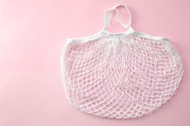 White string bag on pink background, top view. Space for text