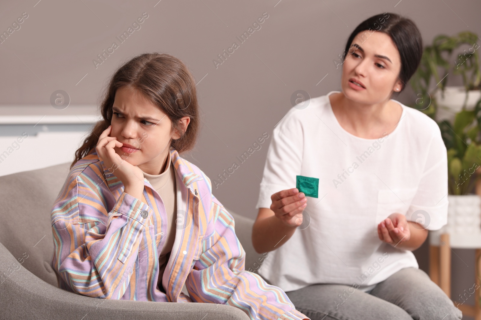 Photo of Mother talking with her teenage daughter about contraception at home. Sex education concept