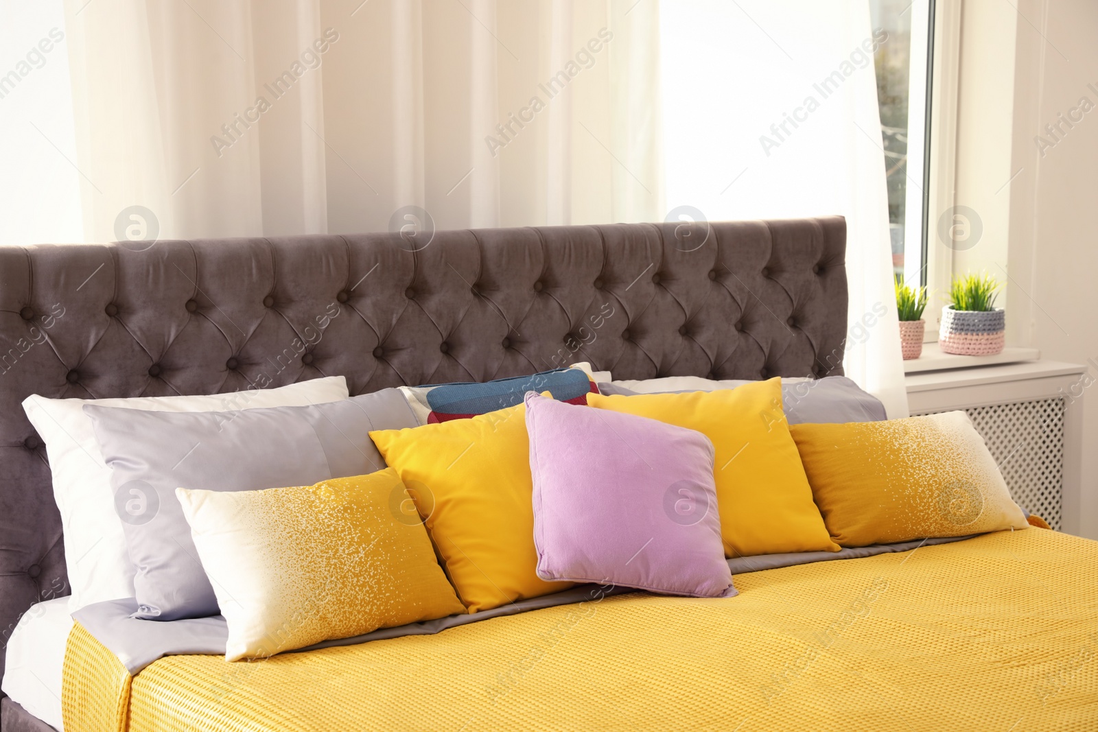 Photo of Different pillows on bed in room. Idea for interior decor