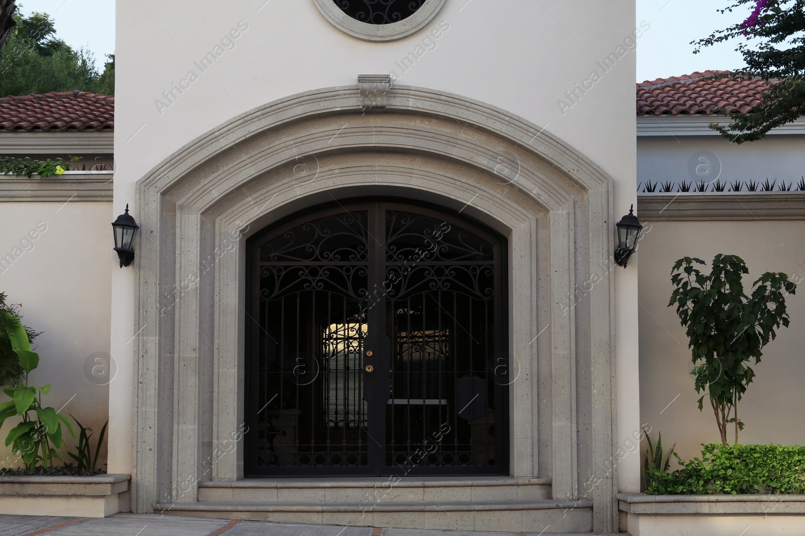 Photo of Entrance of house with beautiful arch and metal gate
