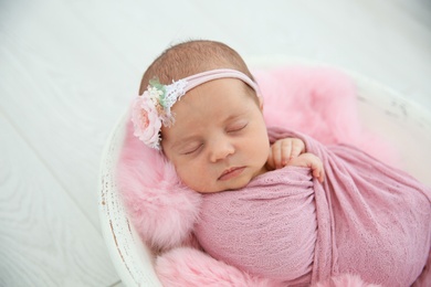 Photo of Adorable newborn girl lying in baby nest, closeup