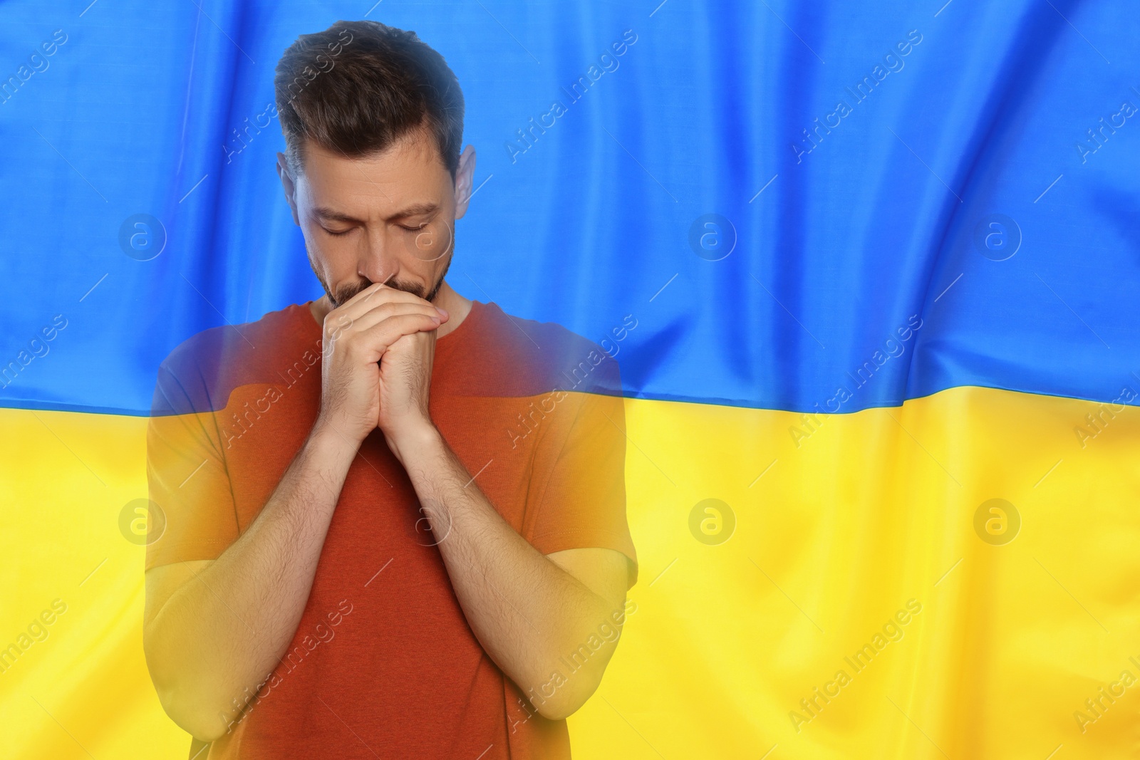 Image of Double exposure of national flag and man praying. Stop war in Ukraine