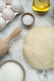 Photo of Fresh yeast dough and ingredients on white marble table, flat lay