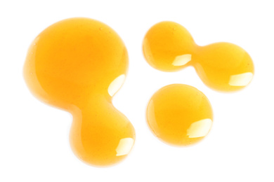 Photo of Drops of delicious honey on white background