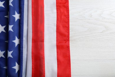 American flag on white wooden table, top view. Space for text