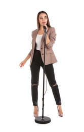 Young stylish woman in jacket posing with microphone on white background