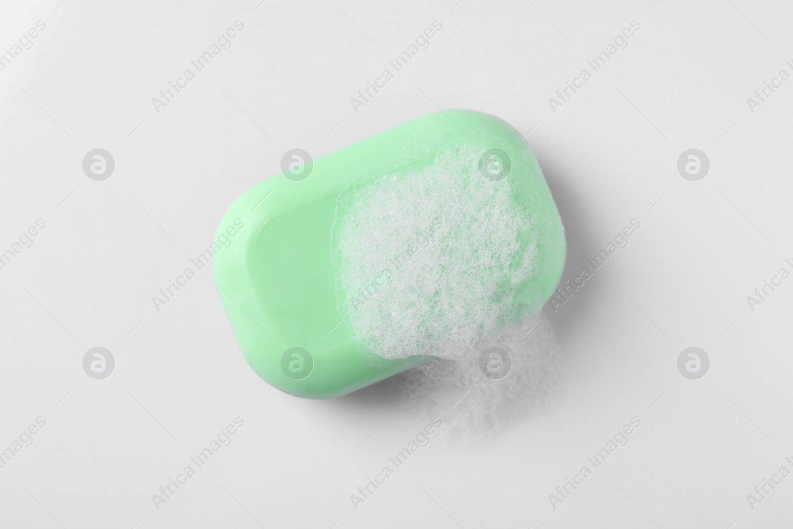 Photo of Soap with fluffy foam on white background, top view